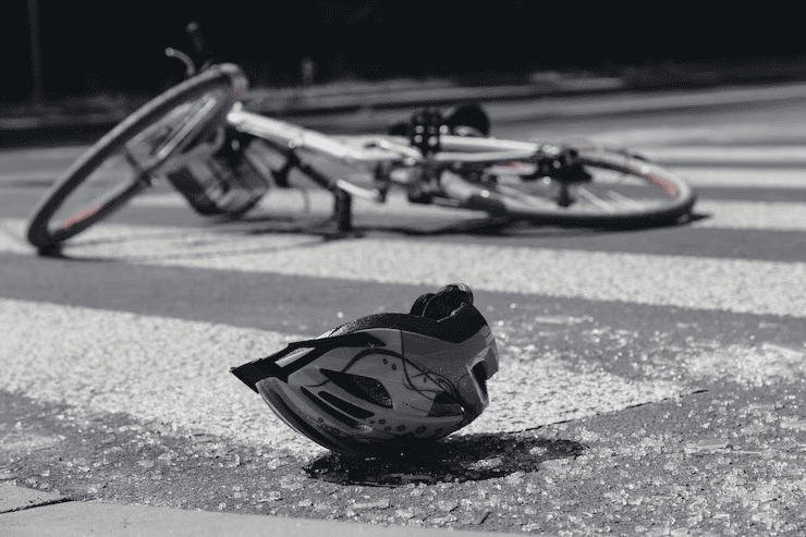 bicycle and a helmet on the ground because of a bicycle accident