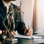 La estatua de la Dama de la Justicia sobre el escritorio de un abogado especializado en lesiones personales, que simboliza la equidad y la búsqueda de la justicia en los asuntos legales.
