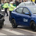 Uber vehicle collides with another car on road, showing crash damage. Rideshare liability, auto insurance claim, and personal injury concept.