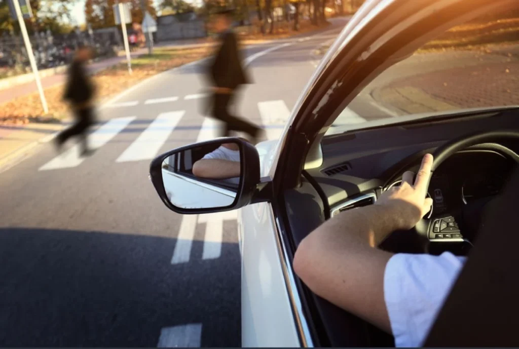 Car approaching pedestrians, indicating an impending road accident, relevant for personal injury claims.