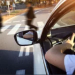 Car approaching pedestrians, indicating an impending road accident, relevant for personal injury claims.