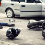 Motorcycle rider lying down on the road after getting involved in a road accident, highlighting the severity of motorcycle crashes and relevant for personal injury claims."
