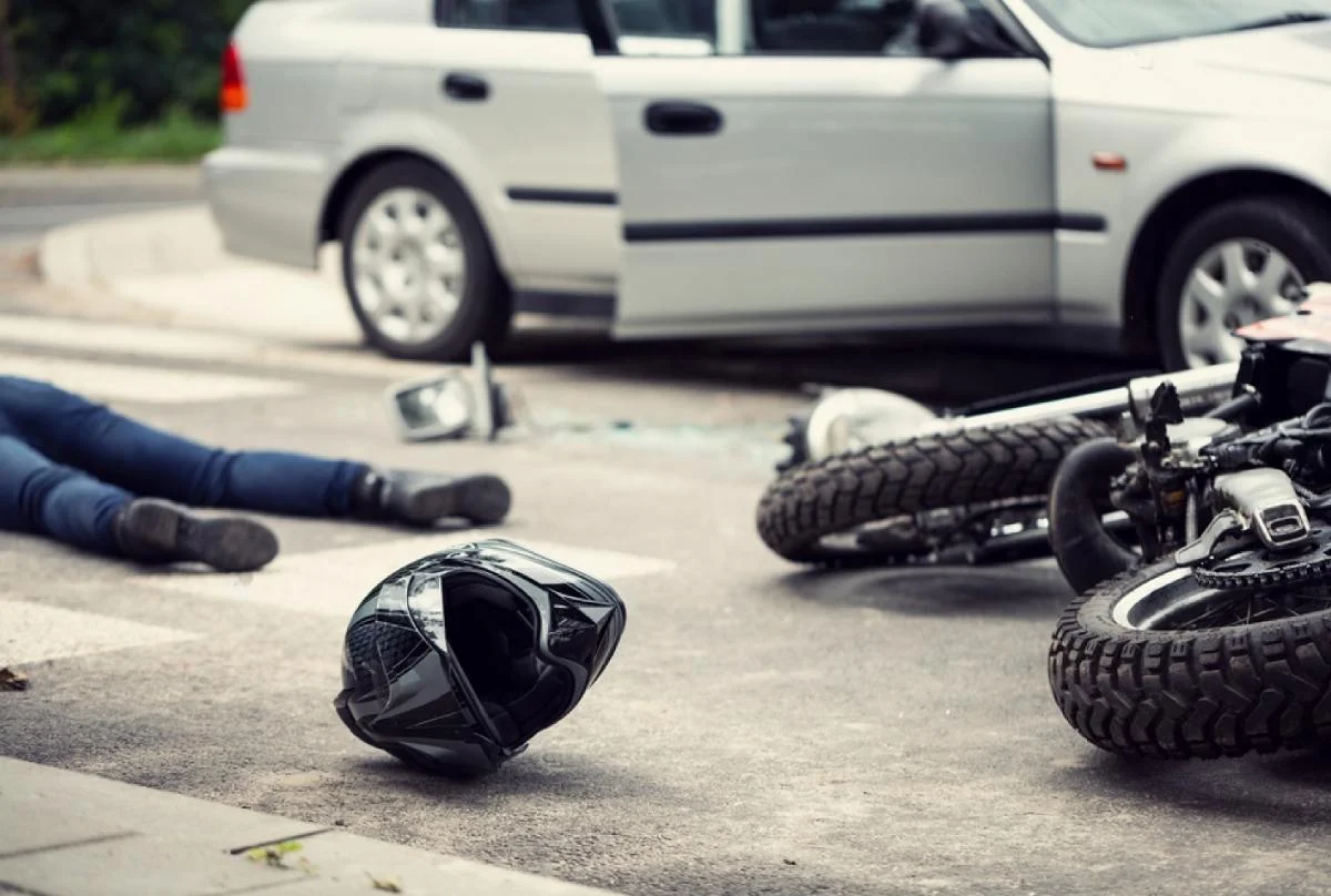 Motorcycle rider lying down on the road after getting involved in a road accident, highlighting the severity of motorcycle crashes and relevant for personal injury claims.