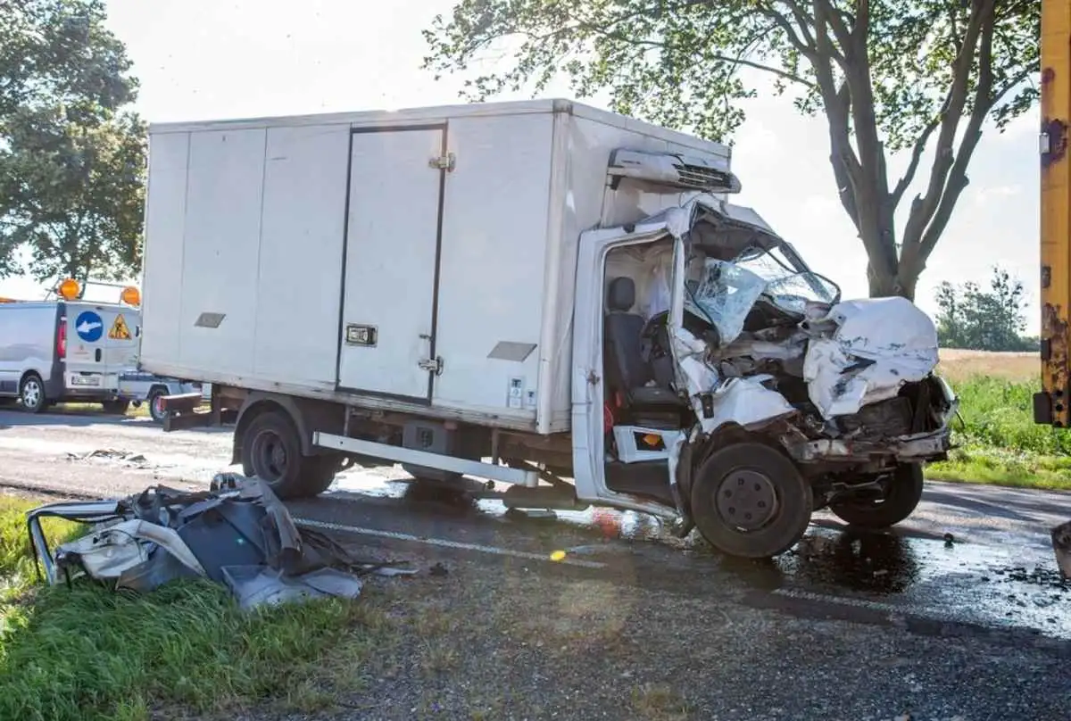 White commercial car badly wrecked in the front from a road accident, highlighting the severity of vehicle collisions and relevant for personal injury claims.