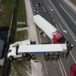 Two trailer trucks involved in an accident on a busy highway, highlighting the dangers of truck collisions and relevant for personal injury claims.