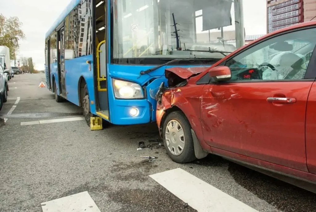 Blue bus and red sedan crashed, illustrating the impact of vehicle collisions and relevant for personal injury claims.