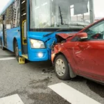 Blue bus and red sedan crashed, illustrating the impact of vehicle collisions and relevant for personal injury claims.