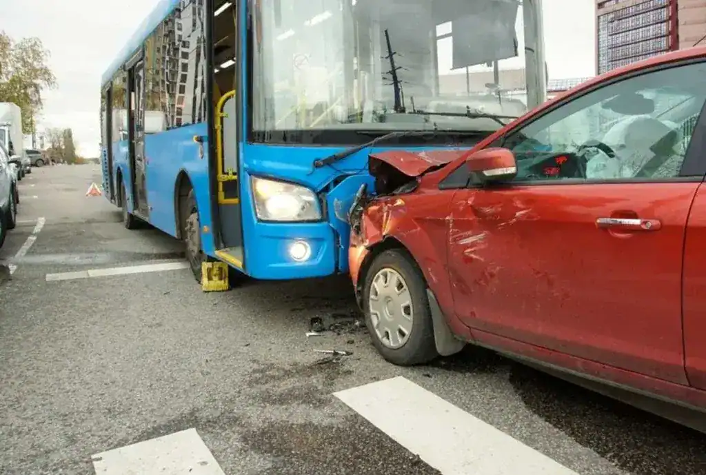 Blue bus and red sedan crashed relevant for personal injury claims. Austin bus accident lawyer