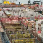 Aerial view of an active construction site with scaffolding and rebar
