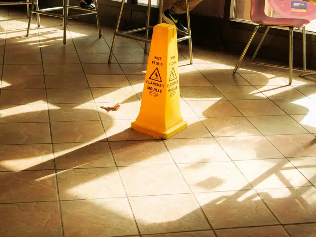Yellow wet floor caution sign on a tiled floor, illustrating a premises liability hazard