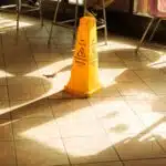 Yellow wet floor caution sign on a tiled floor, illustrating a premises liability hazard